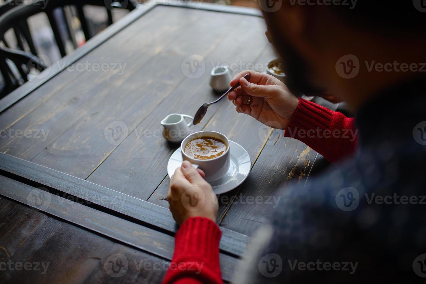 couple tenant des tasses à café tricotées vêtues d'un pull photo