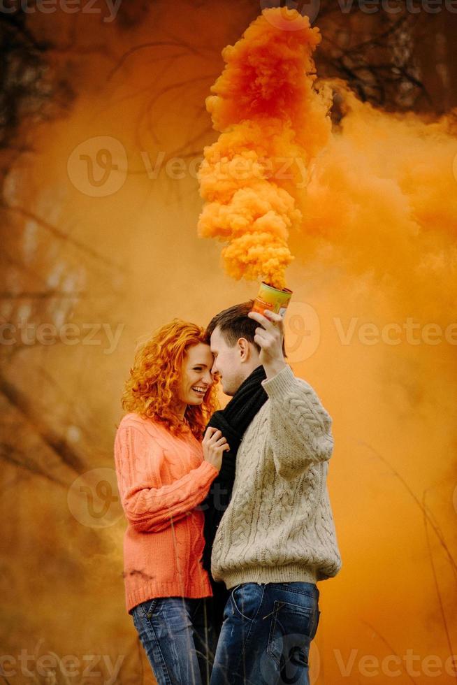jeune couple heureux tenant des bombes fumigènes sur le camping photo