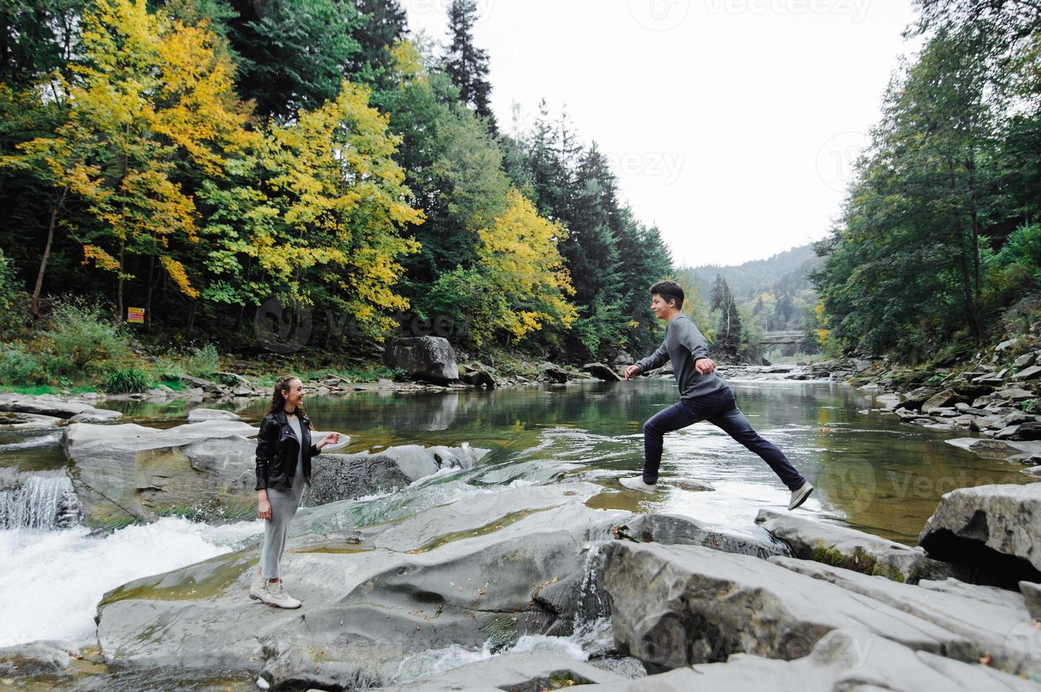 incroyablement beau et charmant couple sur le fond d'une rivière de montagne photo