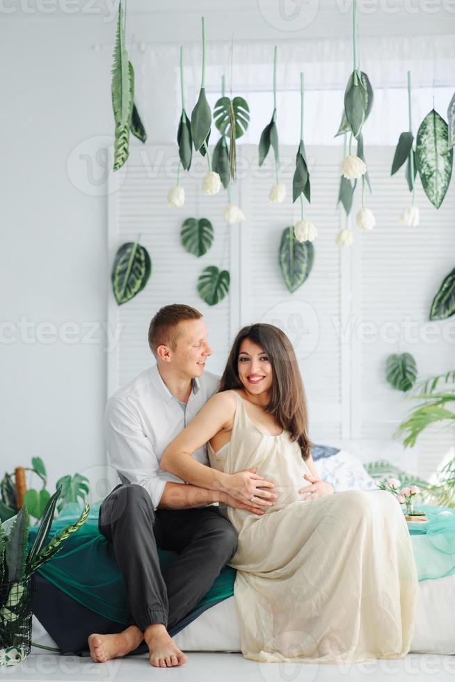 couple avec une femme enceinte se reposant sur un canapé ensemble photo