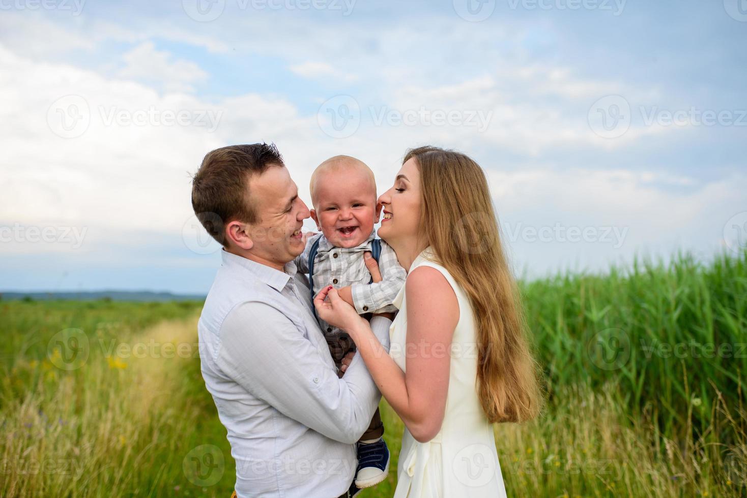 père et mère conduisent leur fils d'un an par la main. photo