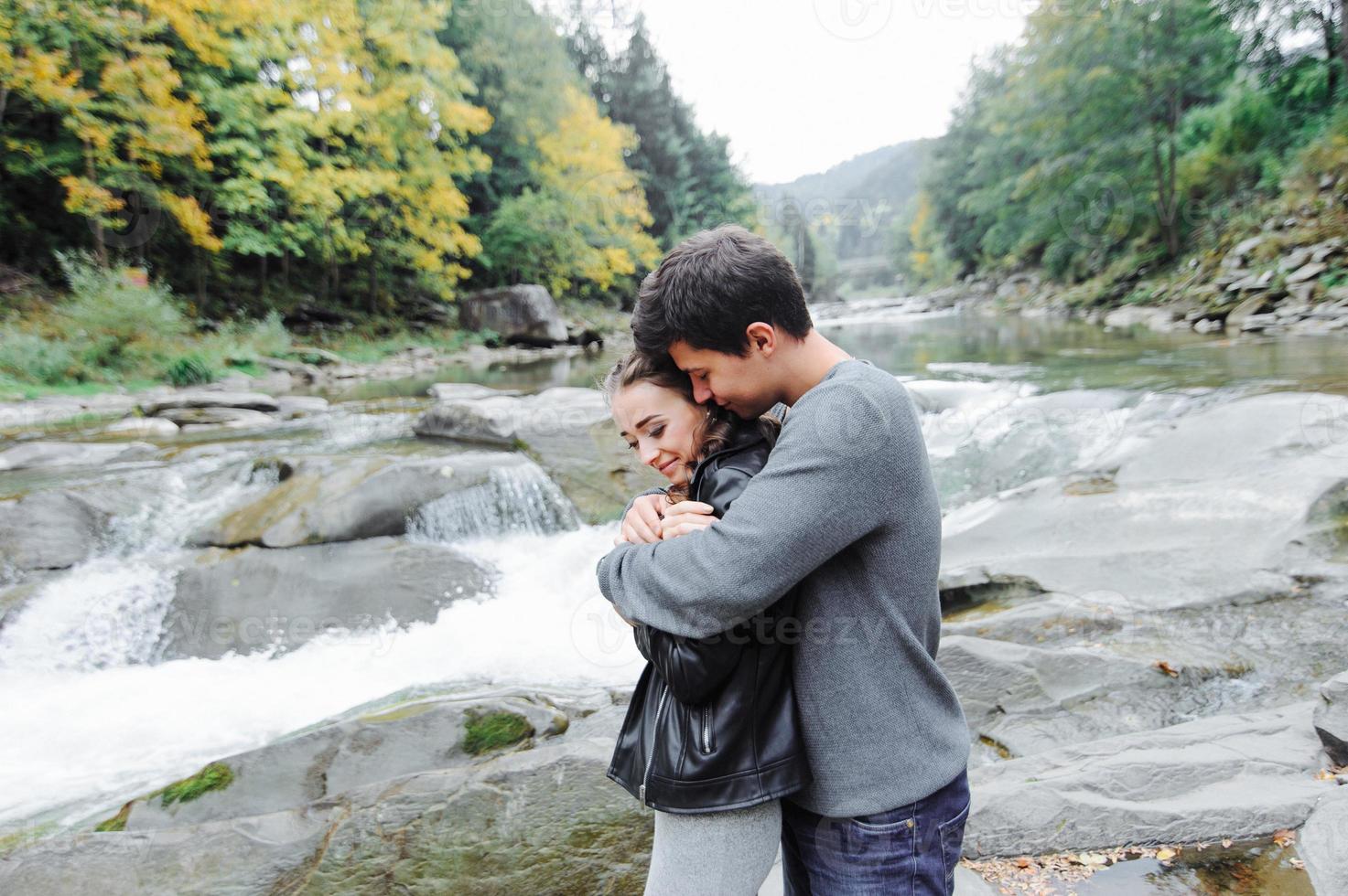 incroyablement beau et charmant couple sur le fond d'une rivière de montagne photo