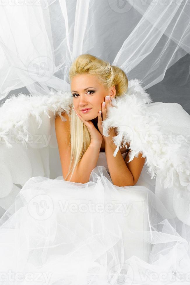 femme blonde sexy en costume d'ange posant devant la caméra. photo