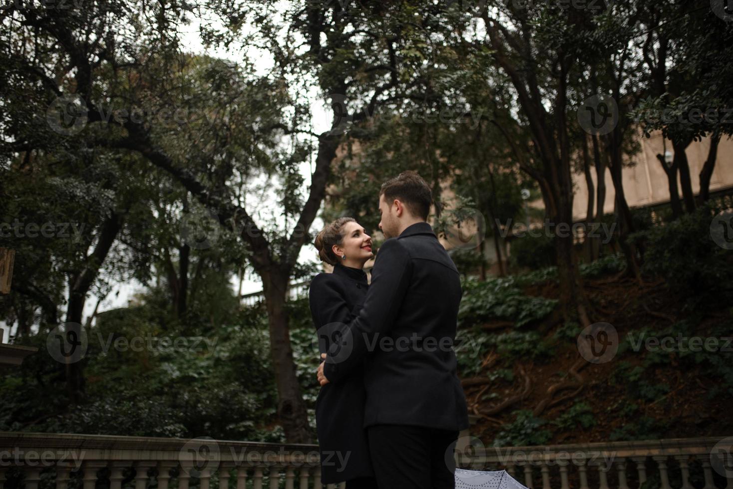 jeune beau couple hispanique aimant se promène sous un parapluie pendant la pluie. photo