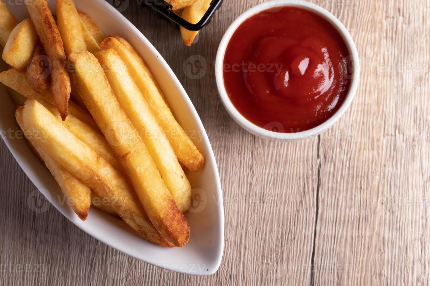 frites dans un panier noir avec sauce tomate photo