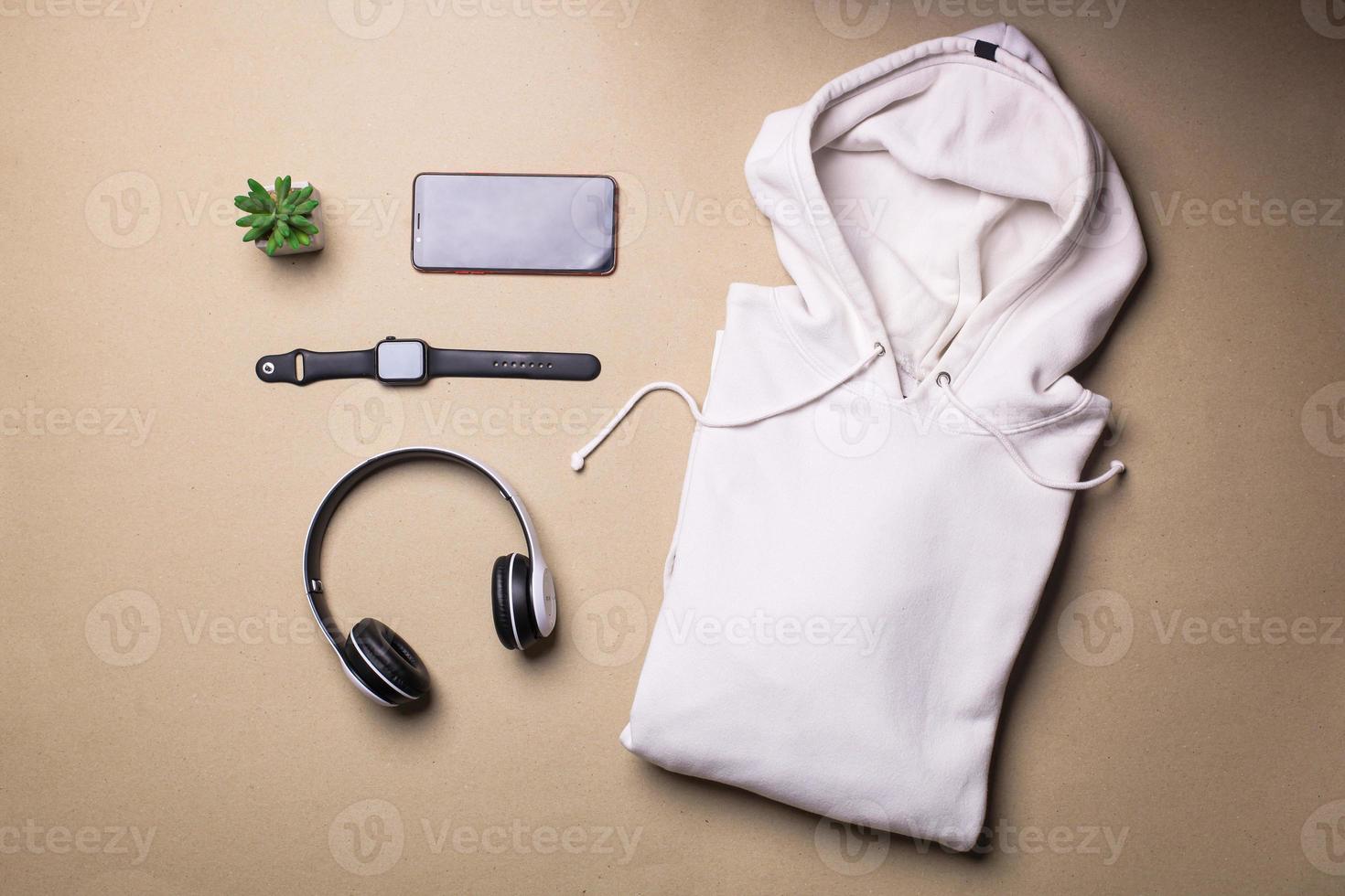 maquette d'un pull à capuche blanc plié avec des accessoires pour homme photo