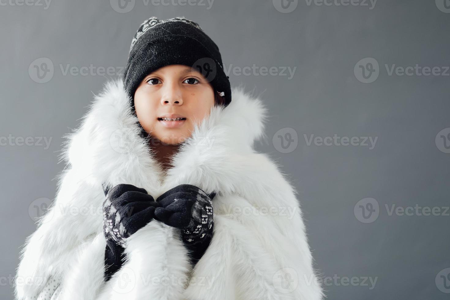 mignon garçon portant des vêtements d'hiver pendant la saison d'hiver photo