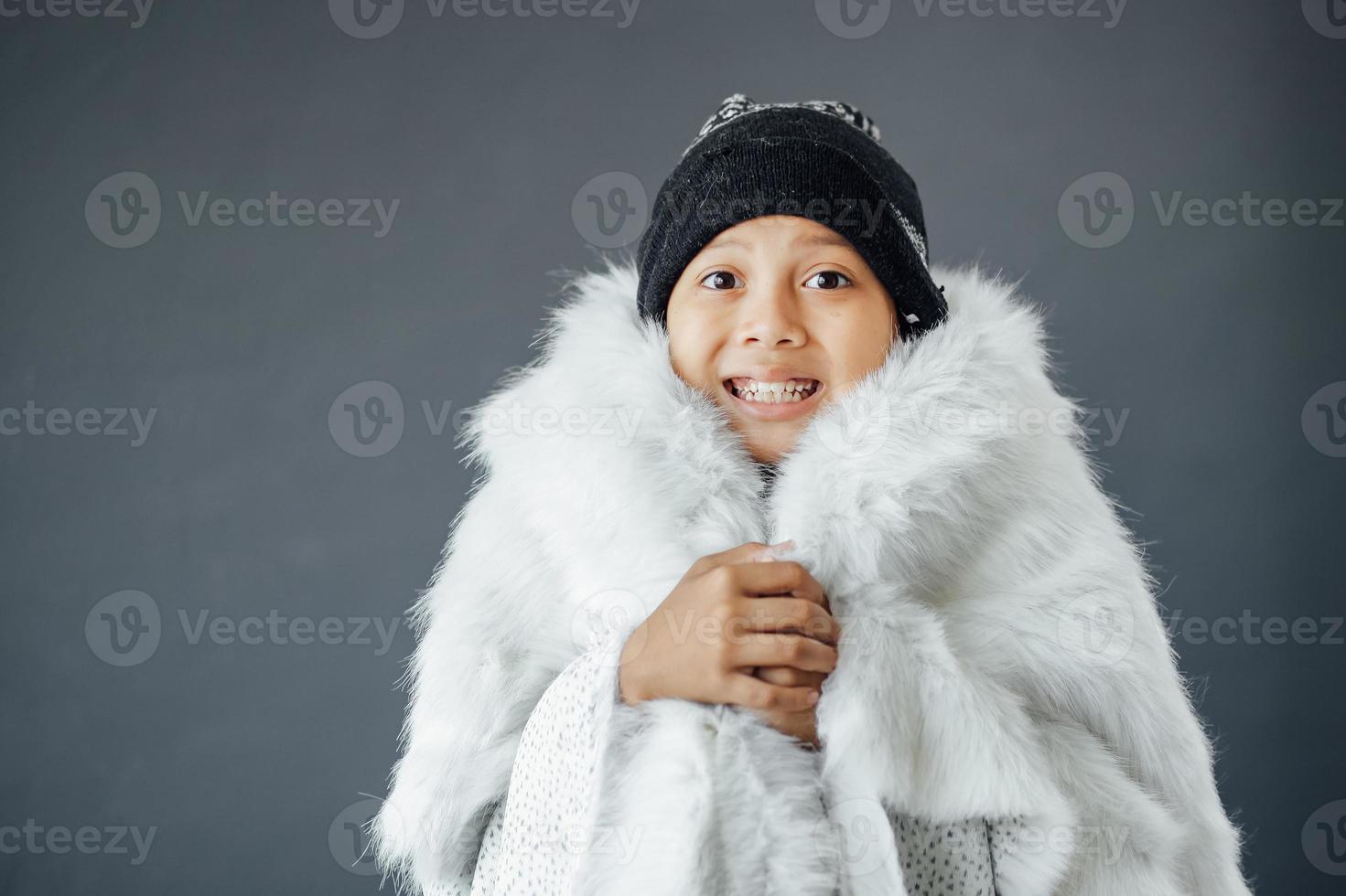 mignon garçon portant des vêtements d'hiver se sentant froid pendant la saison d'hiver photo