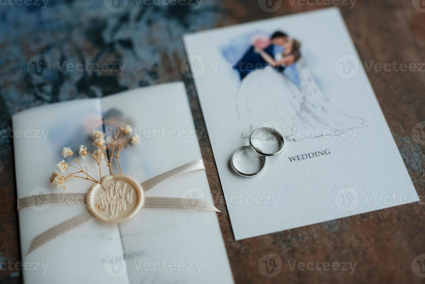 anneaux de mariage en or avec une invitation mariage photo