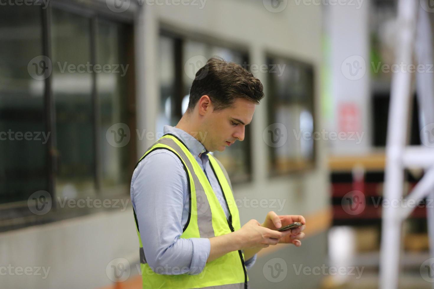 ingénieur industriel hommes portant un casque de sécurité tout en se tenant dans une usine industrielle lourde. la maintenance du travail sur des machines industrielles et la configuration du système de sécurité en usine. photo