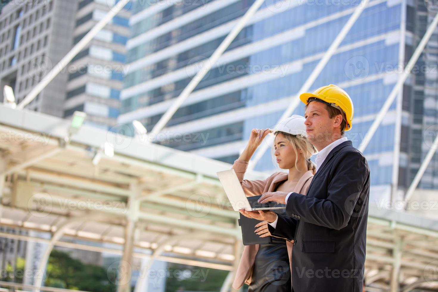 l'ingénieur et la femme d'affaires vérifient le presse-papiers sur le chantier de construction. le concept d'ingénierie, de construction, de vie urbaine et d'avenir. photo