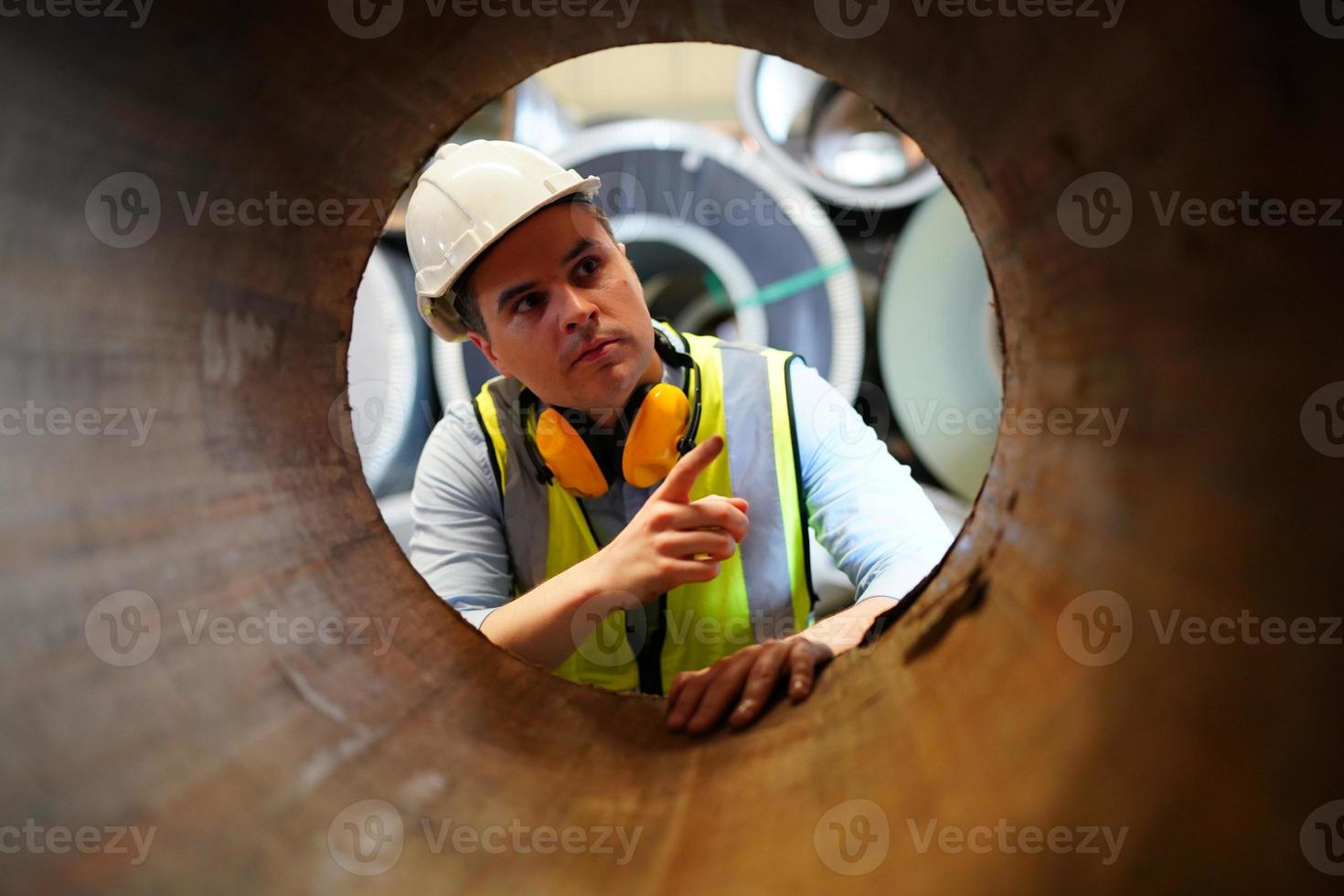 le contremaître ou le travailleur de l'industrie travaille sur le site de l'usine pour vérifier la machine ou les produits sur le site. ingénieur ou technicien vérifiant le matériel ou la machine sur l'usine. industriel et usine. photo