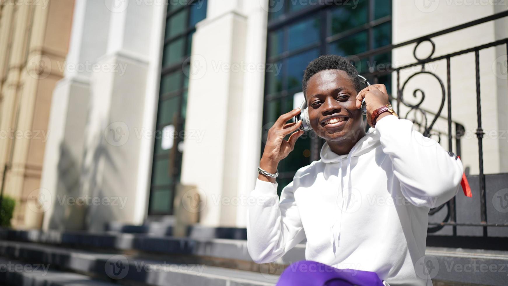 homme afro-américain s'amusant à marcher dans le centre-ville - jeune homme heureux profitant d'un coucher de soleil en plein air - mode de vie de la génération du millénaire et concept d'attitude positive des personnes photo