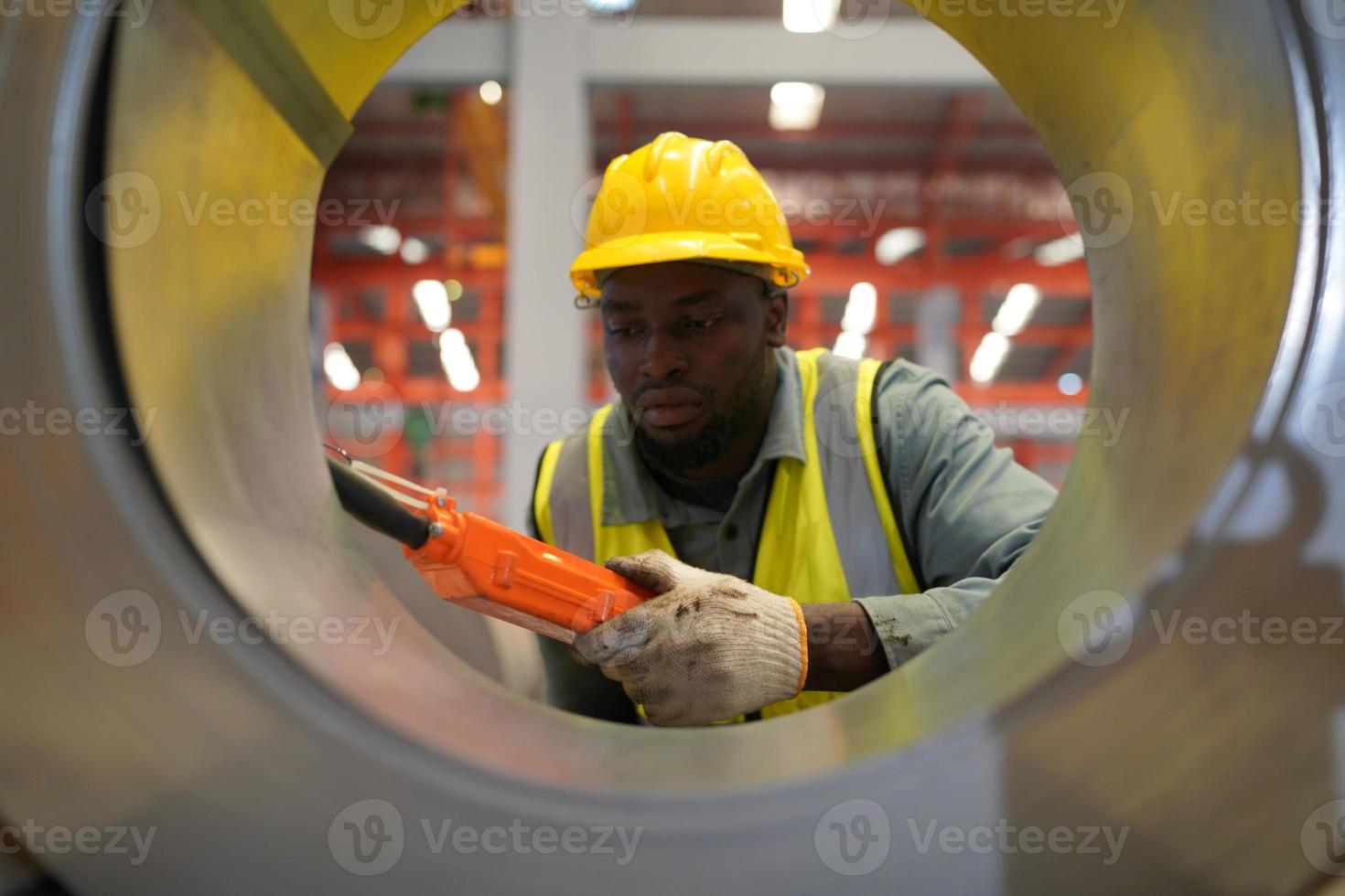 le contremaître ou le travailleur de l'industrie travaille sur le site de l'usine pour vérifier la machine ou les produits sur le site. ingénieur ou technicien vérifiant le matériel ou la machine sur l'usine. industriel et usine. photo