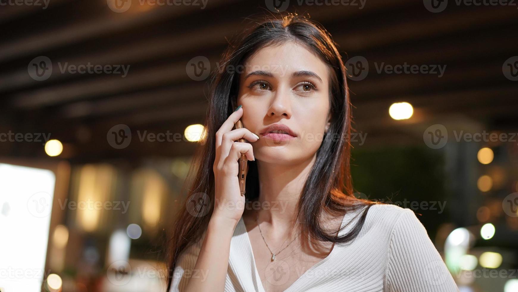 jeune femme parlant au téléphone mobile en plein air. photo