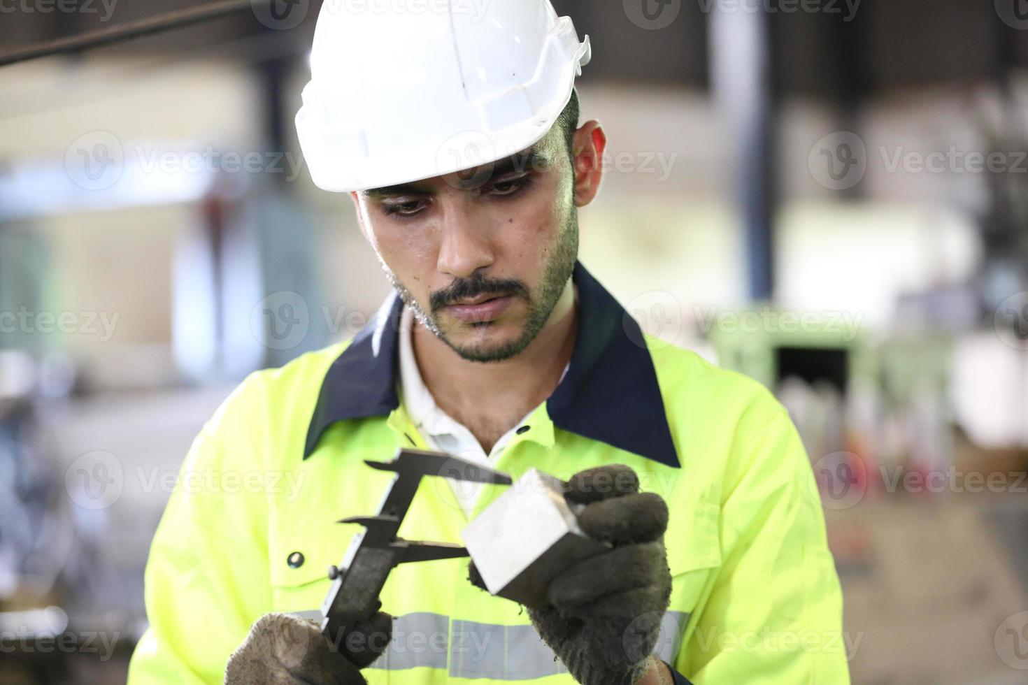 le contremaître ou l'ouvrier travaille sur le site de l'usine pour vérifier la machine ou les produits sur le site. ingénieur ou technicien vérifiant le matériel ou la machine sur l'usine. industriel et usine. photo