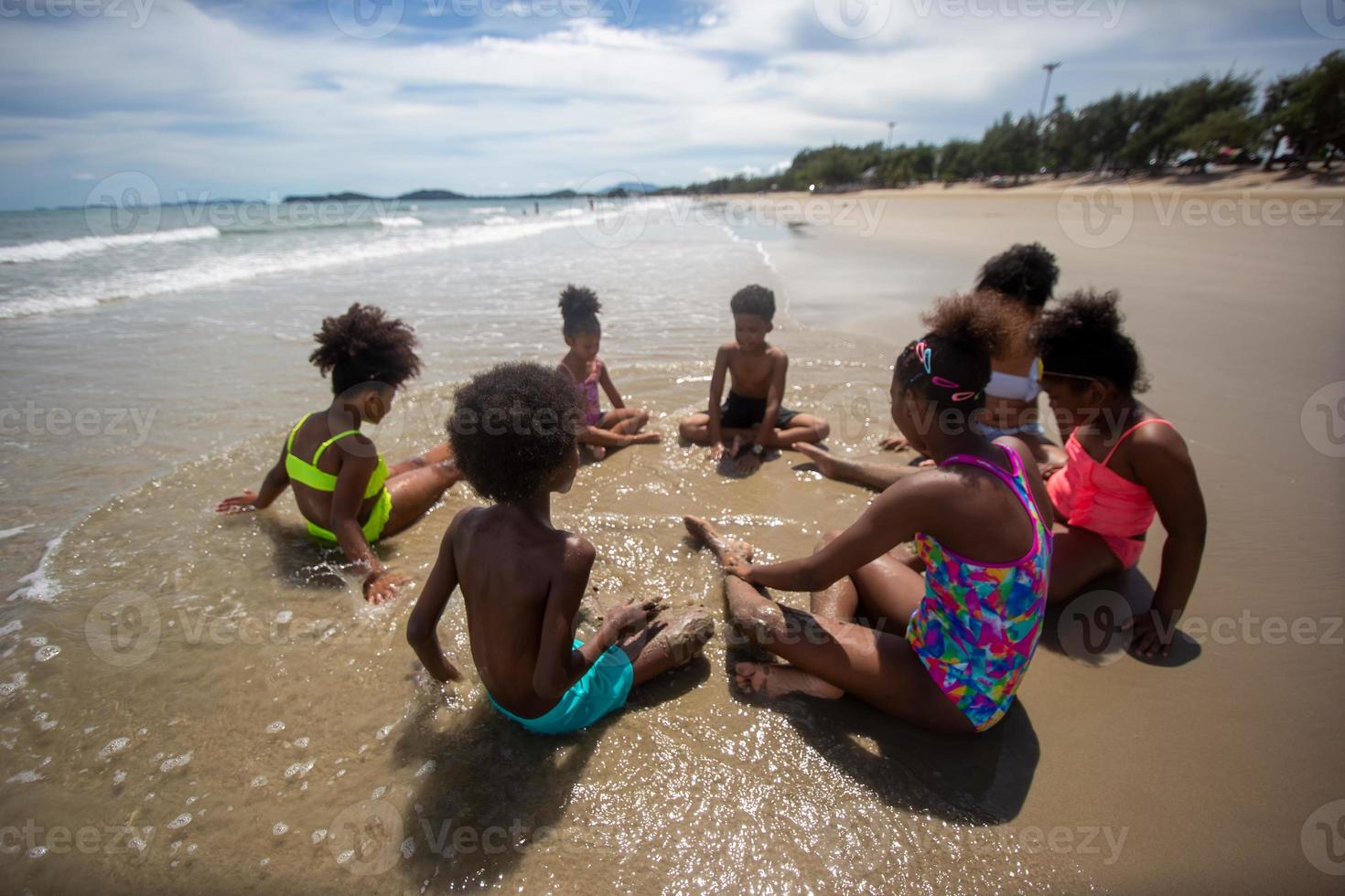 enfants jouant à courir sur le sable à la plage photo