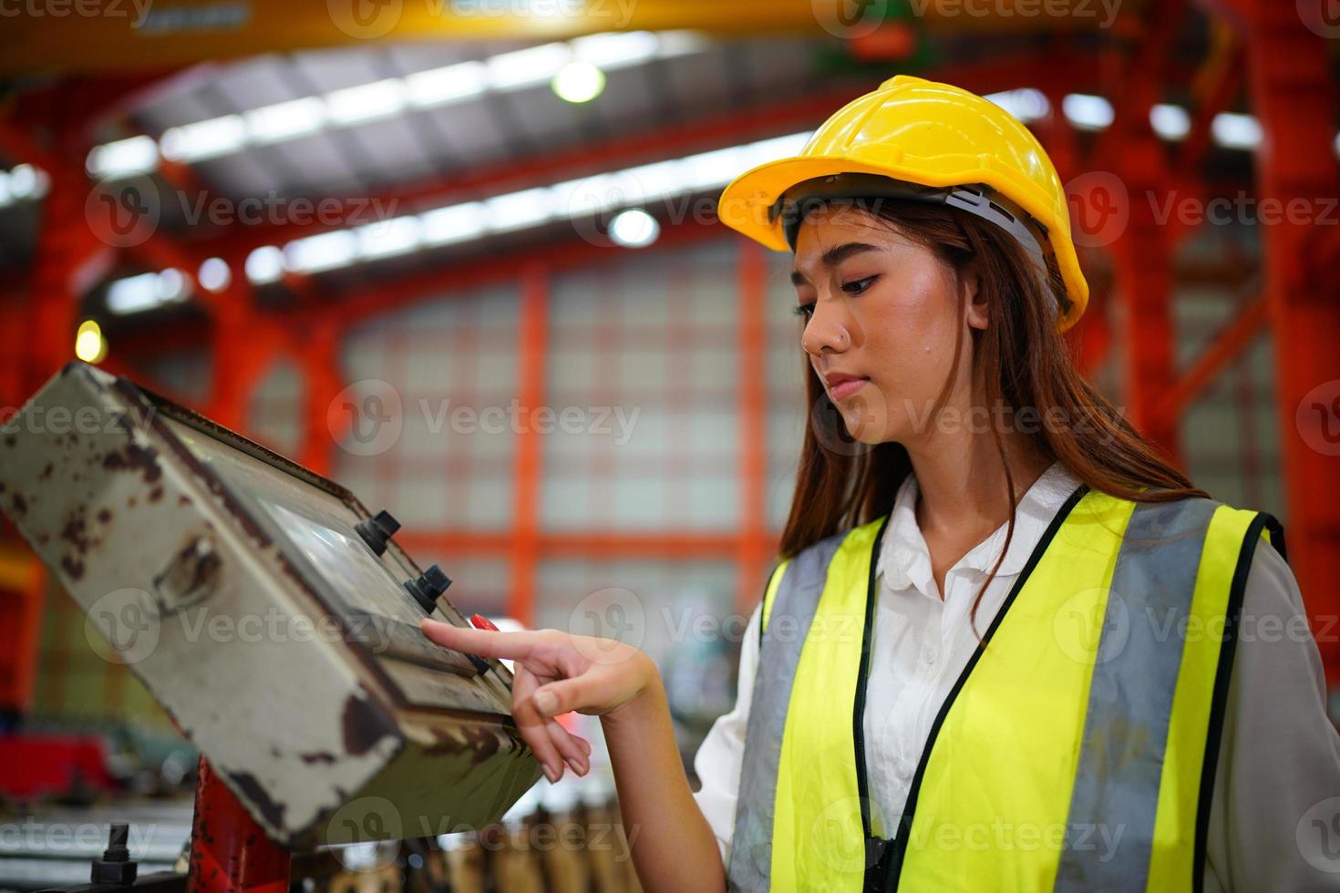 une ouvrière contremaître ou ouvrière travaille sur le site de l'usine pour vérifier la machine ou les produits sur le site. ingénieur ou technicien vérifiant le matériel ou la machine sur l'usine. industriel et usine. photo