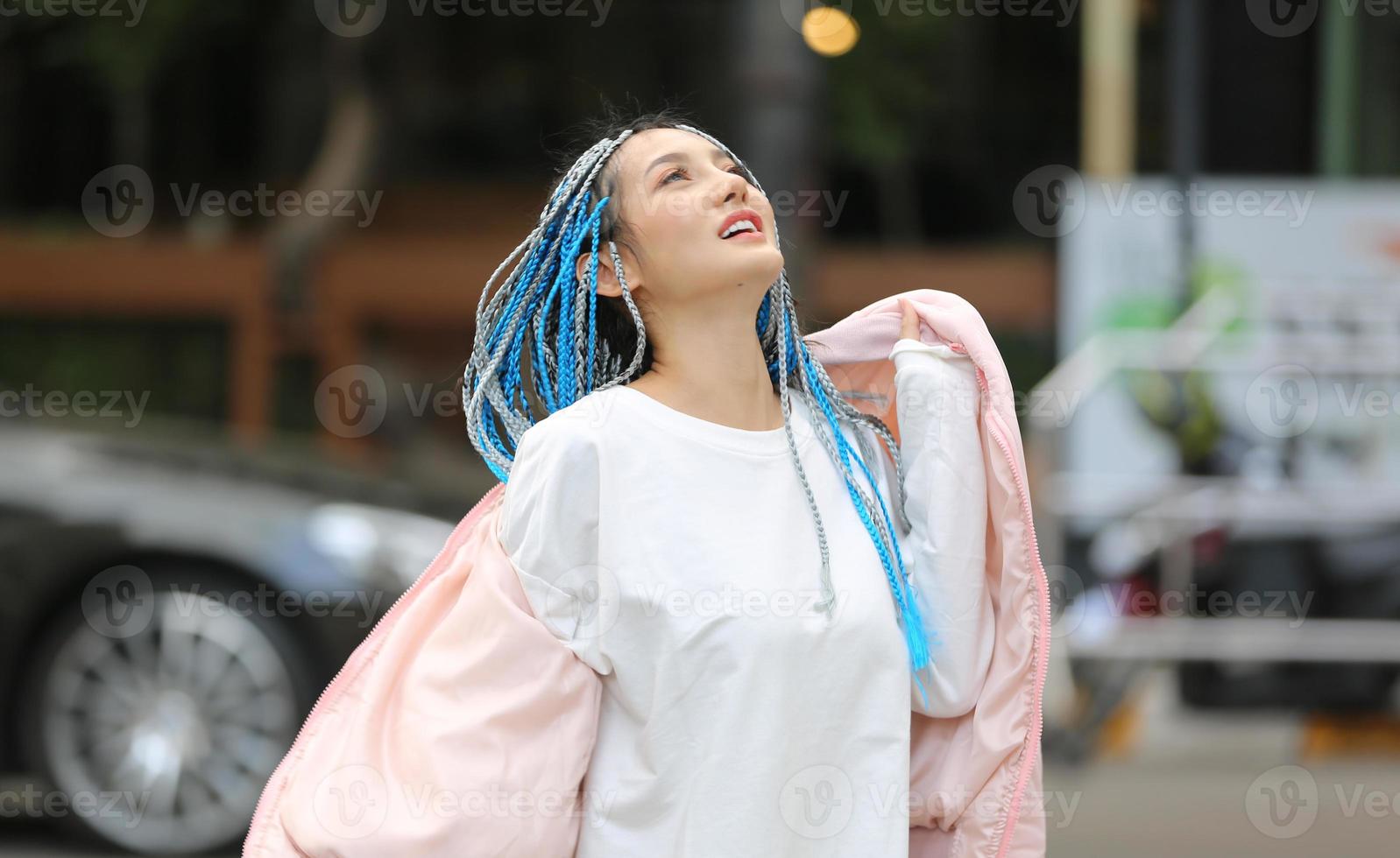 portrait de jeune fille aux cheveux bleus, adolescente debout dans la rue comme vie urbaine. photo