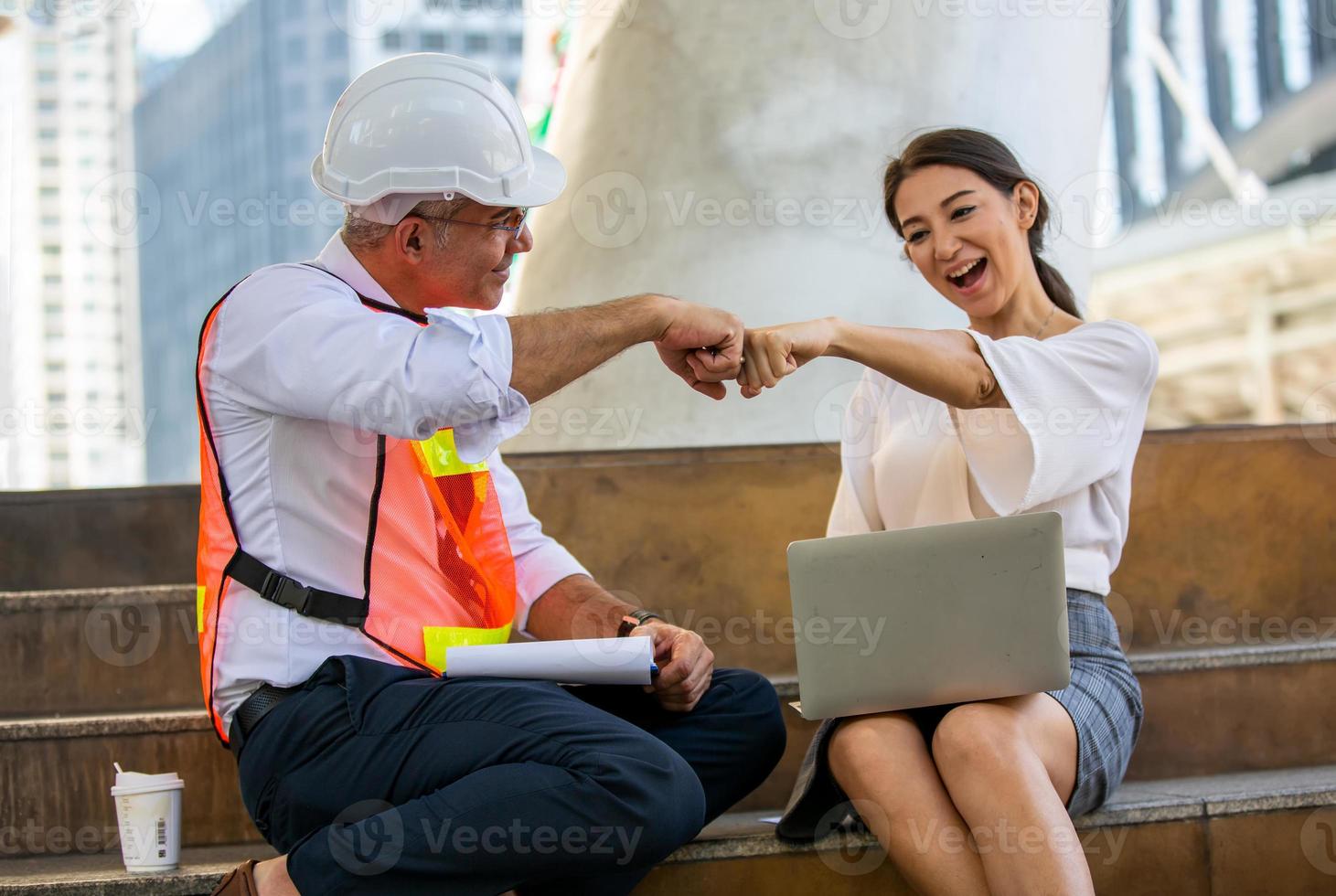 l'ingénieur et la femme d'affaires vérifient le presse-papiers sur le chantier de construction. le concept d'ingénierie, de construction, de vie urbaine et d'avenir. photo