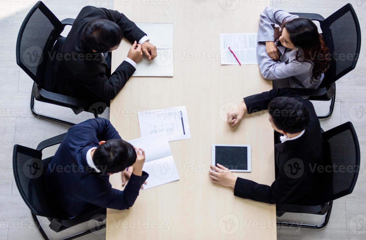 vue de dessus sur un groupe d'hommes d'affaires et de femmes d'affaires ayant une réunion et prenant un engagement commercial. photo