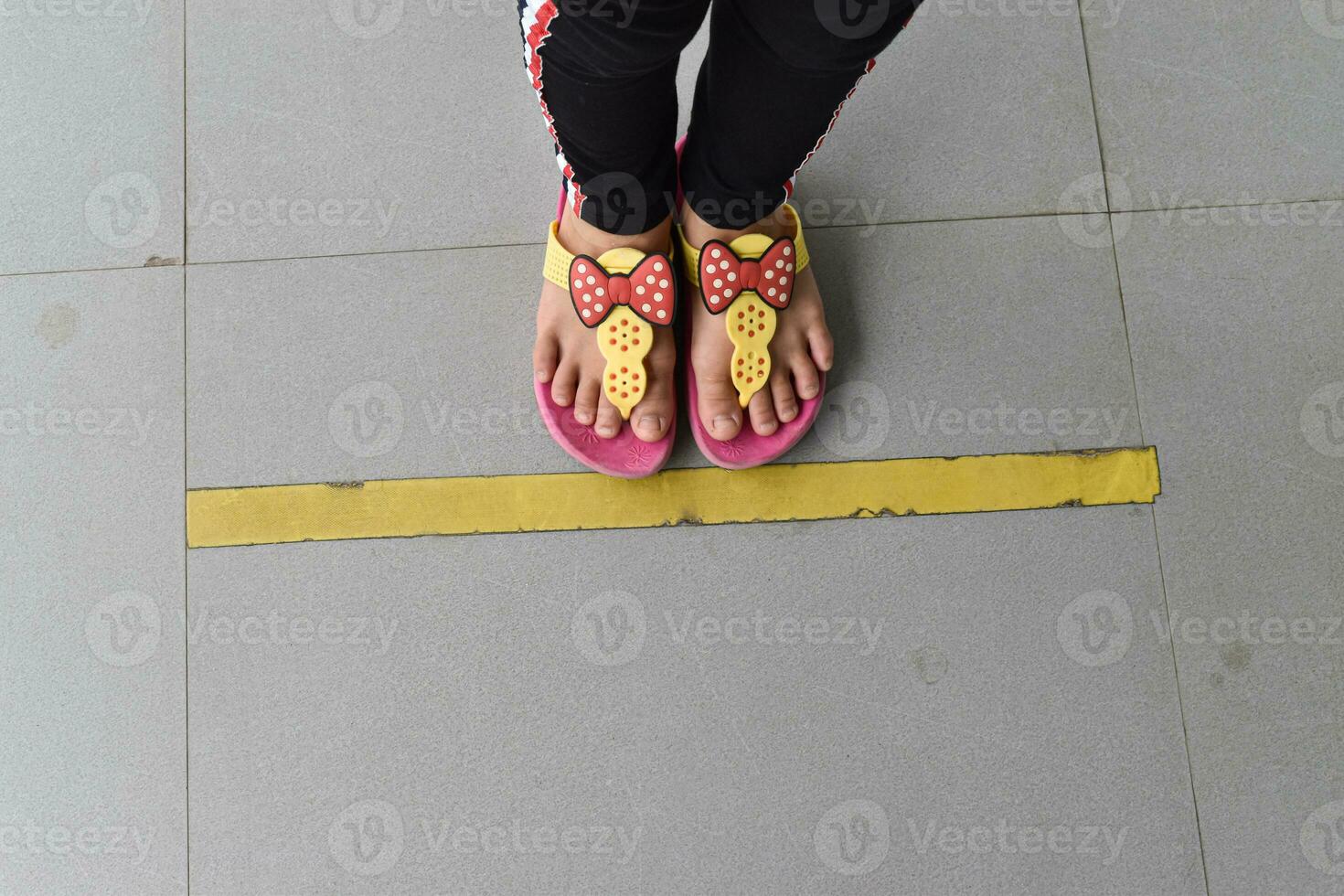 haut vers le bas des pieds alignés sur le sol. concept d'espace public pratiquant la distanciation sociale. photo