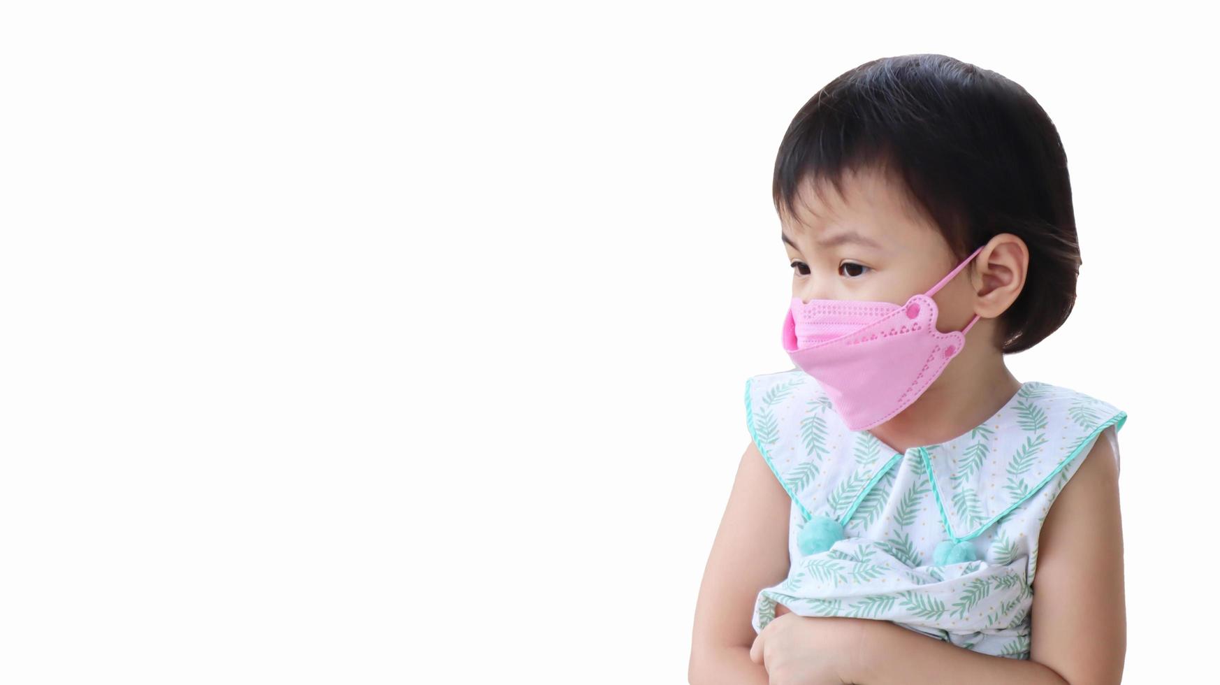 petite fille asiatique enfant d'âge préscolaire portant un masque facial 3d regardant vers la gauche. enfants distraits. photo