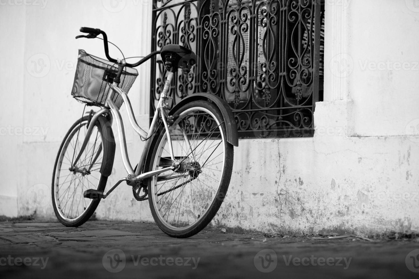 Vélo vintage chromé avec panier à côté d'une fenêtre de la maison photo
