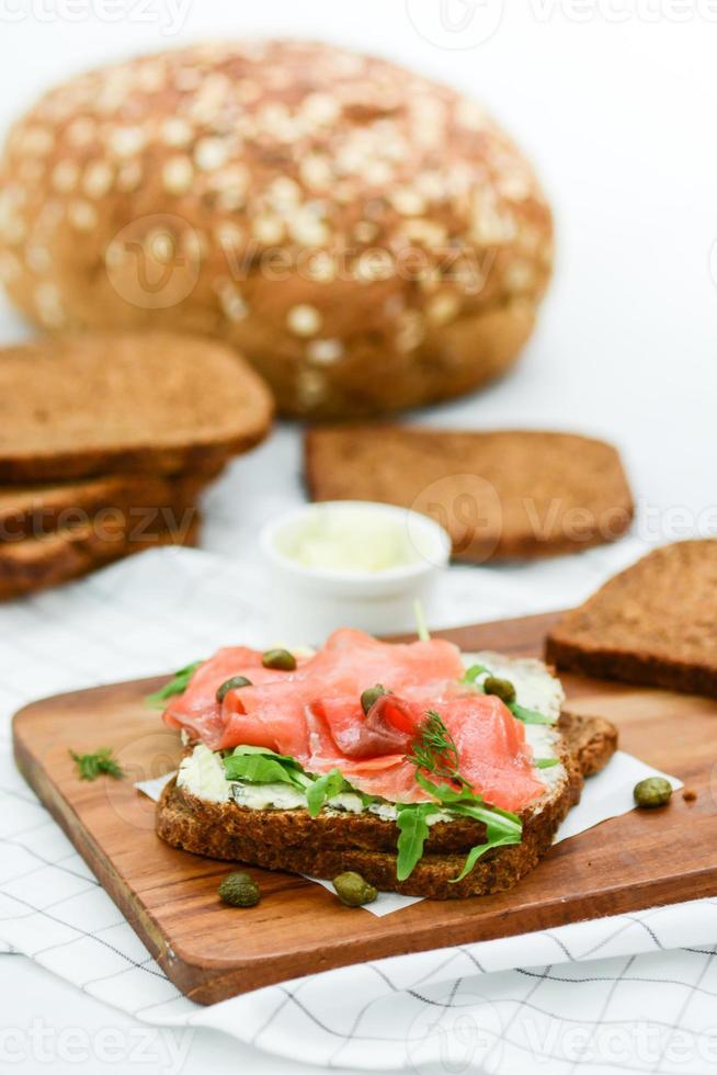 sandwich au saumon fumé avec fromage, pistaches et feuilles de salade, pains bruns photo