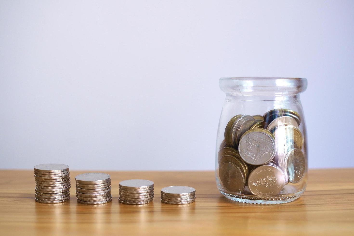 les pièces de monnaie dans des bocaux en verre avec des piles d'argent augmentent pour économiser de l'argent, des idées d'investissement dans les entreprises financières. photo