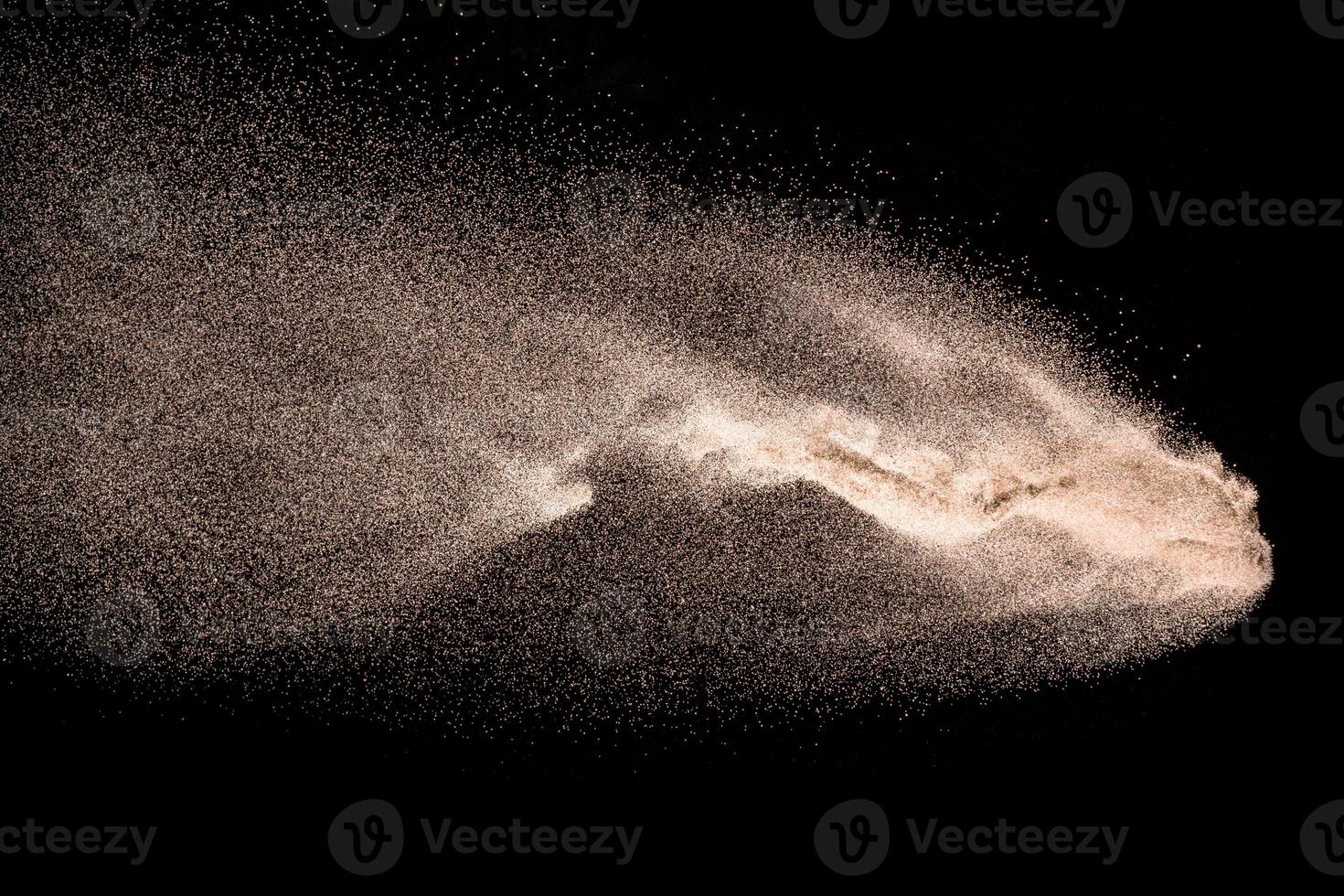 explosion de sable de rivière à sec. éclaboussures de sable de couleur dorée sur fond noir. photo