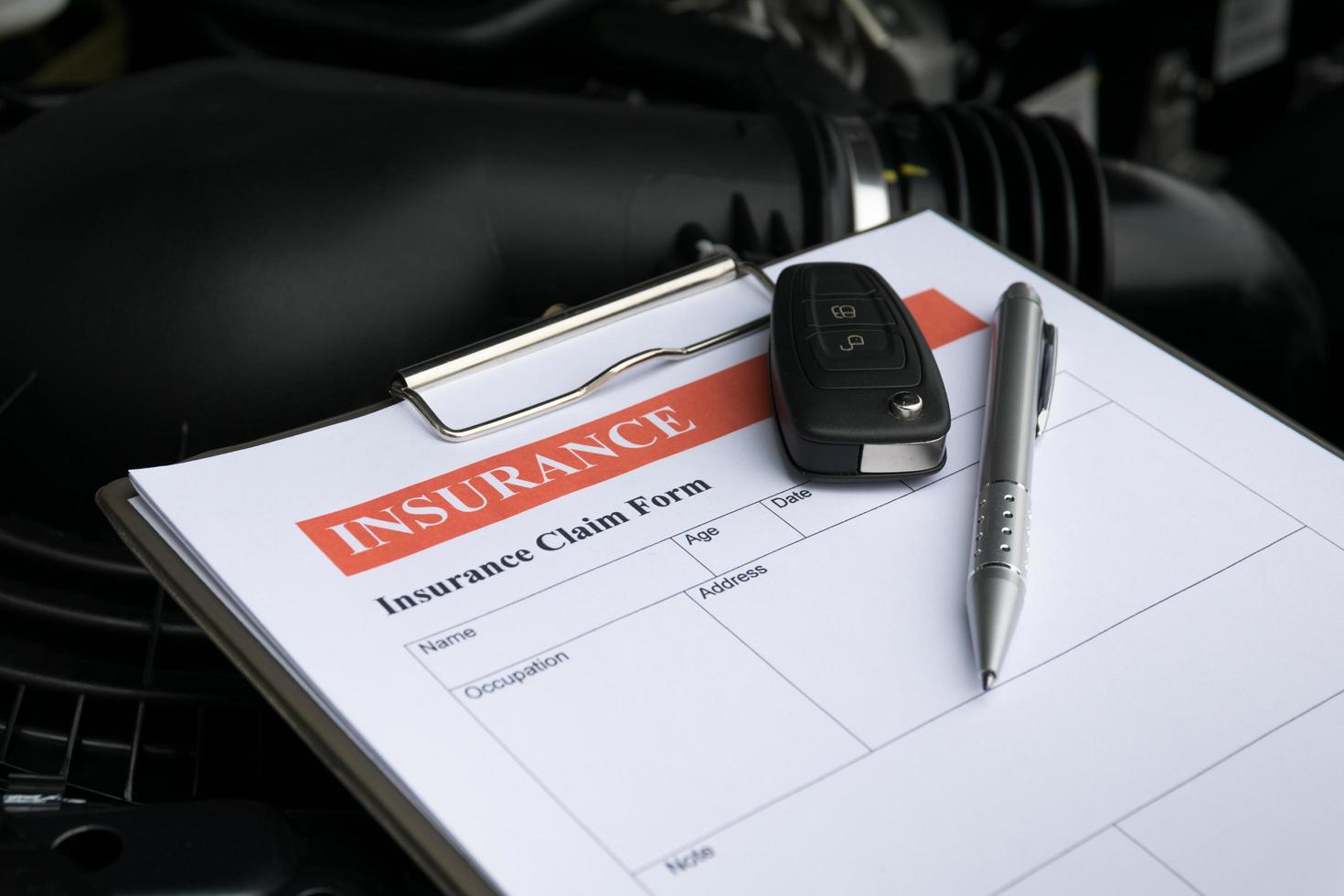 mécanicien inspectant la voiture endommagée et remplissant le formulaire de rapport d'accident photo