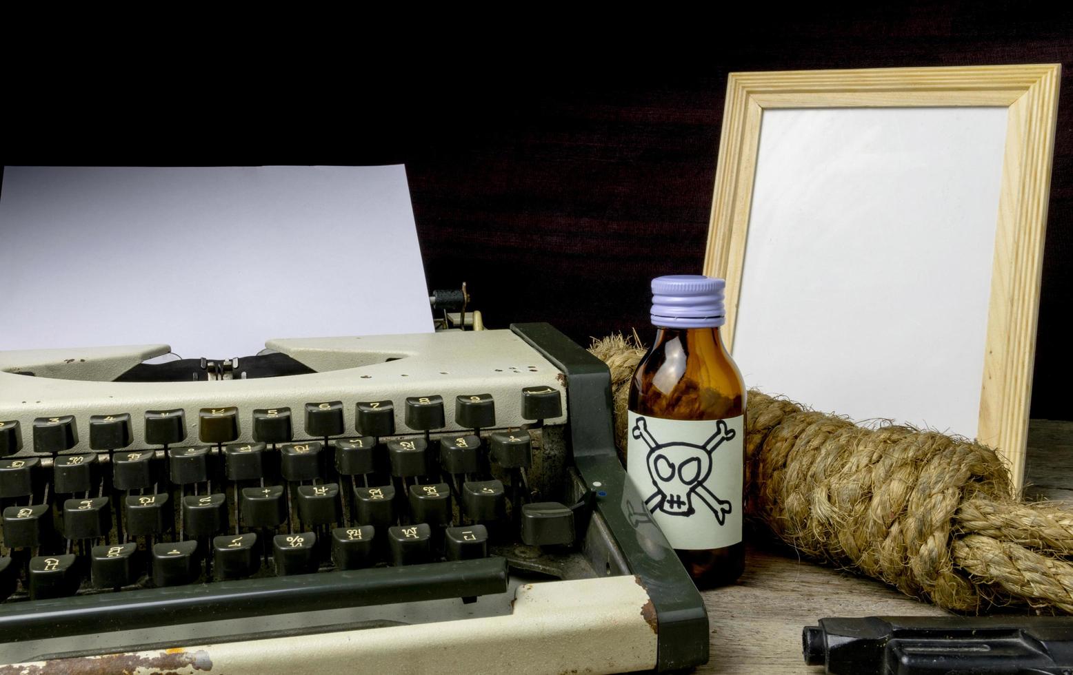 machine à écrire avec page papier et poison et arme à feu. concept scénariste romance suspense photo