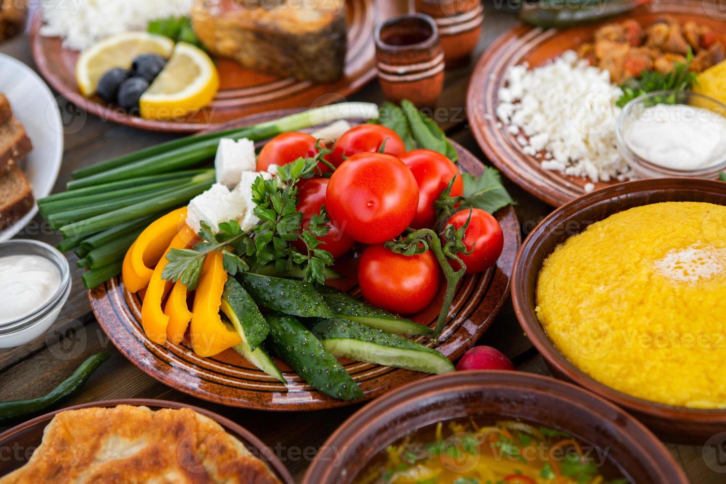 cuisine roumaine maison avec tartes, polenta, bortsch, légumes, poisson, viande, ragoût, fromage et vin. plats traditionnels de la roumanie et de la république de moldavie. photo