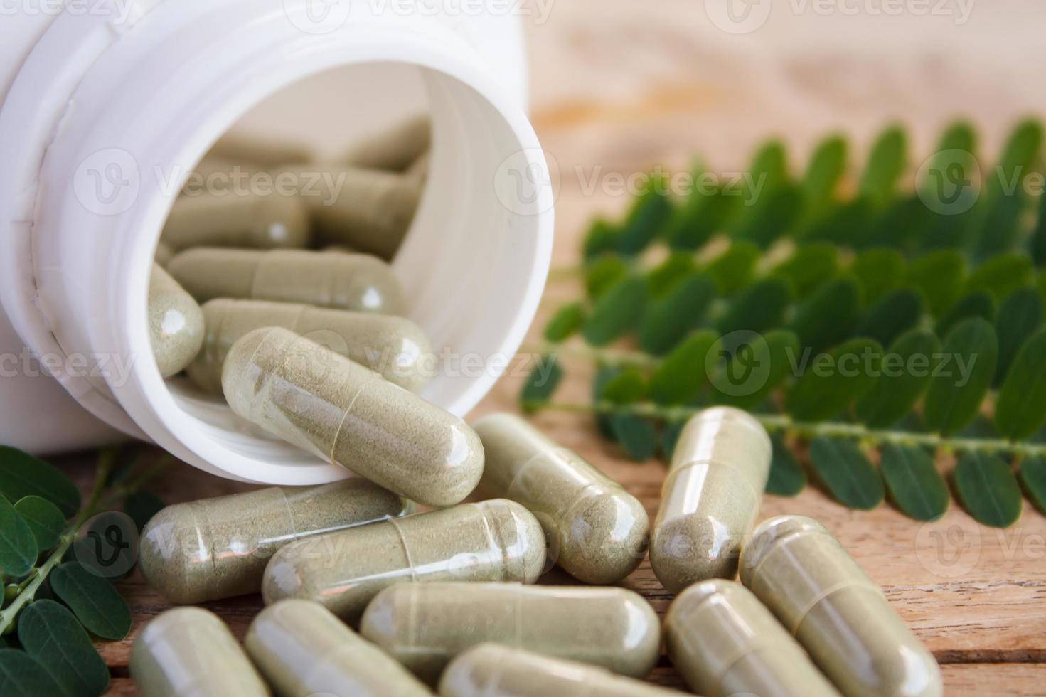 capsules d'herbes débordant d'une bouteille photo