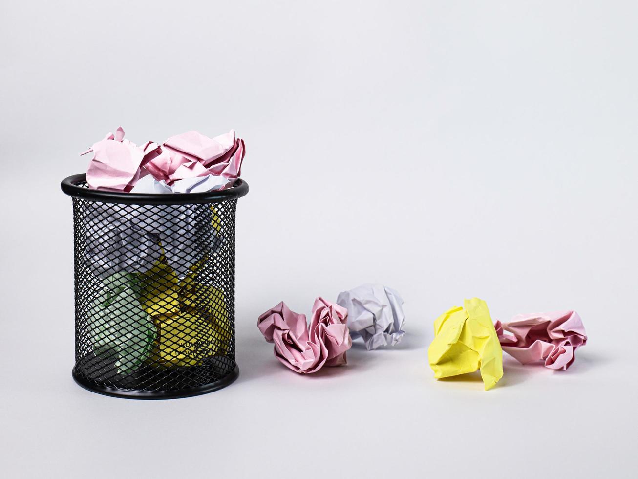 un petit panier noir en acier rond. sert à mettre les poubelles, les documents qui ne fonctionnent pas et qui ont été tellement écrasés qu'ils débordent à l'extérieur. dans le fond blanc, il y a un espace de copie. photo