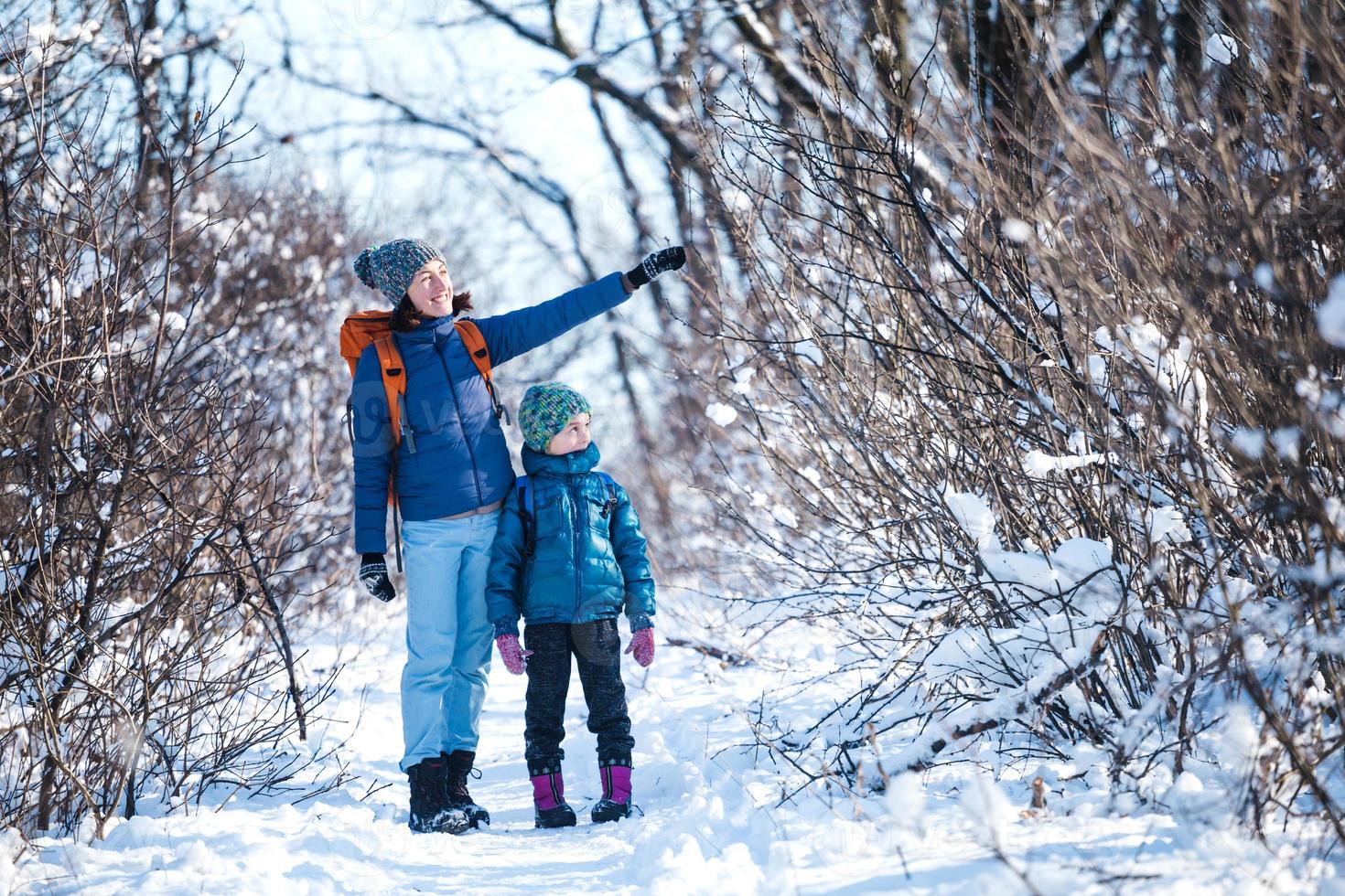 femme avec un enfant lors d'une randonnée hivernale dans les montagnes. photo