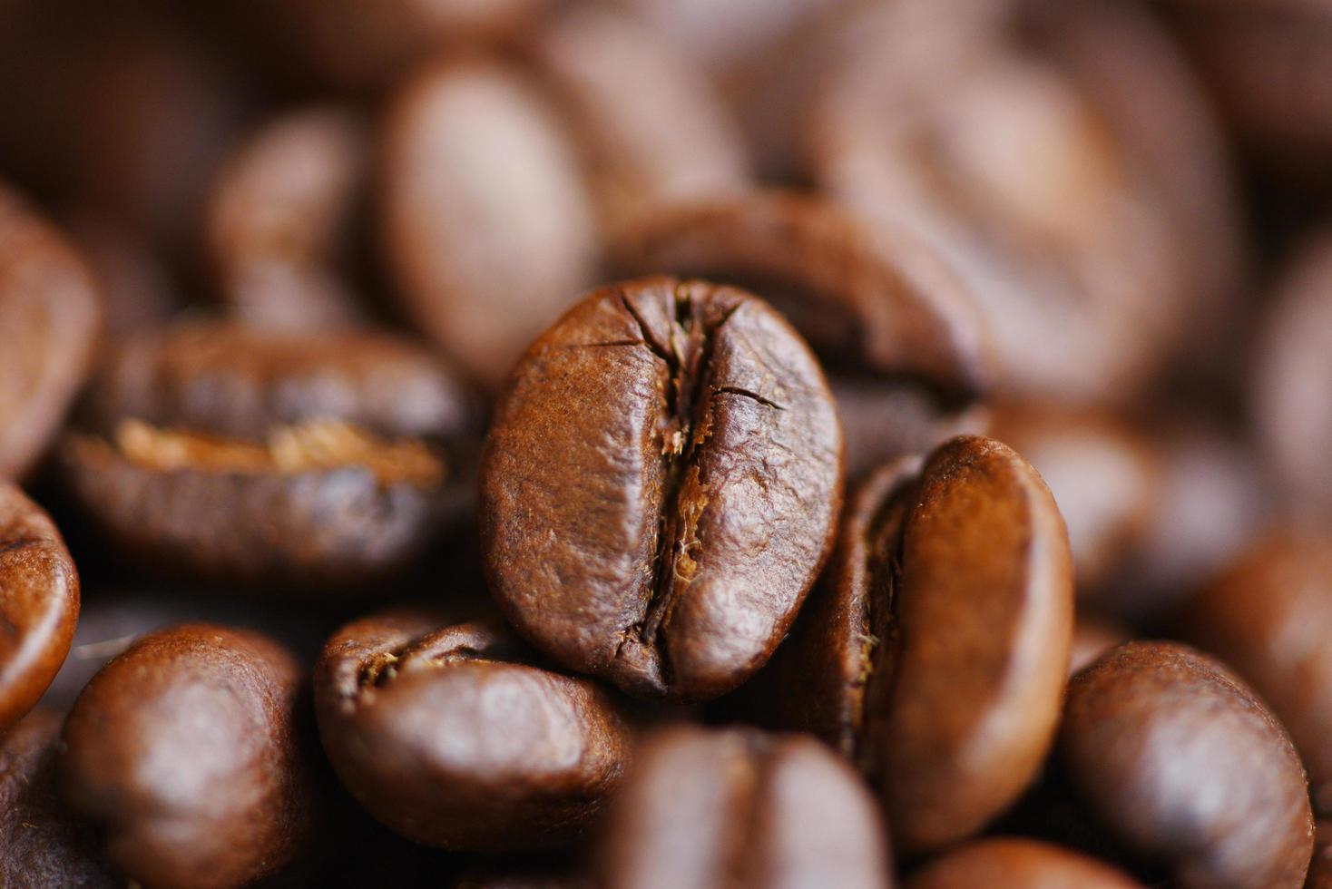 fond de texture de grains de café torréfiés - groupe de macro de grains de café en gros plan photo