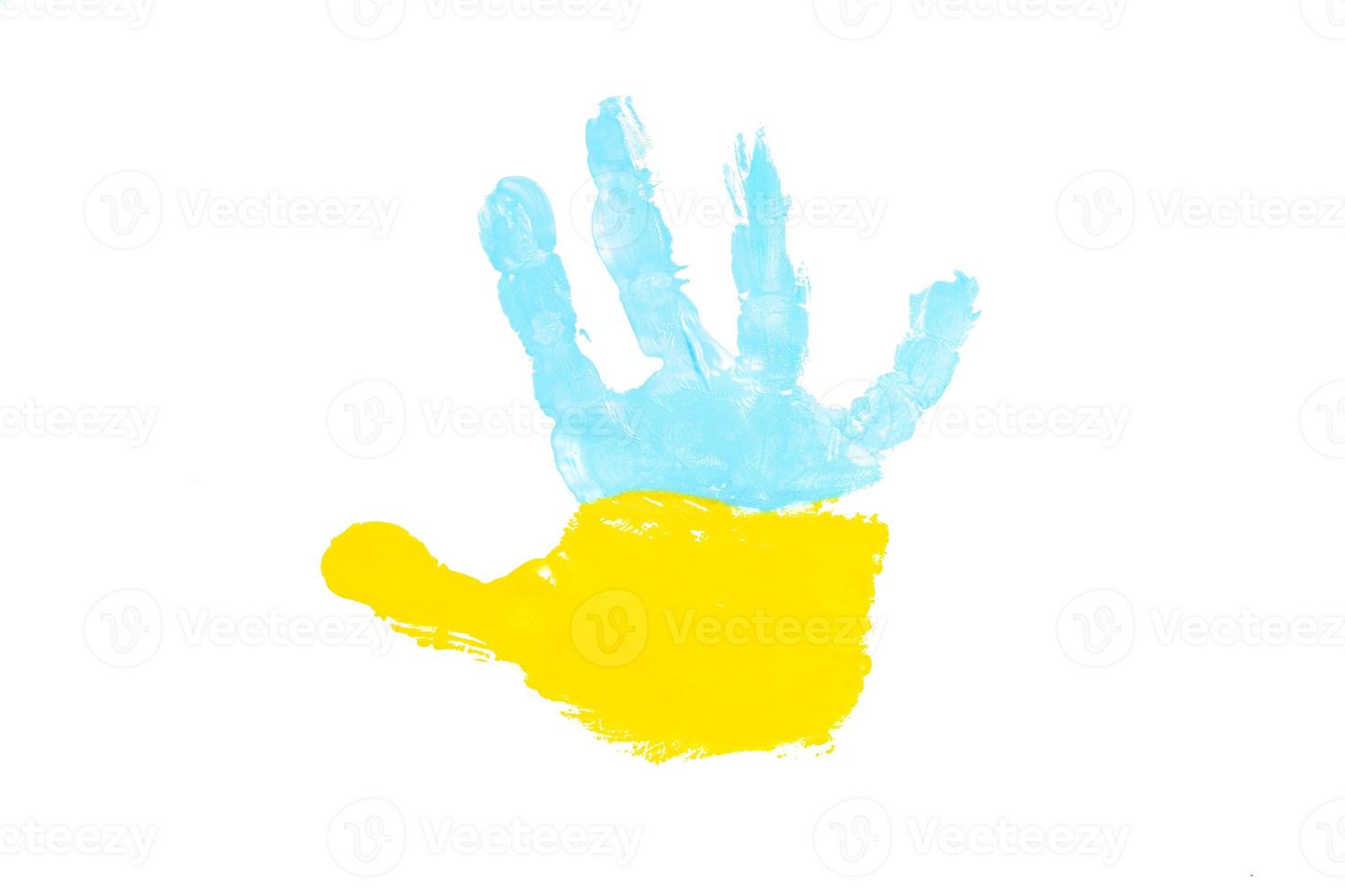 peintures jaunes et bleues de la paume d'un enfant. concept de symboles du drapeau ukrainien photo