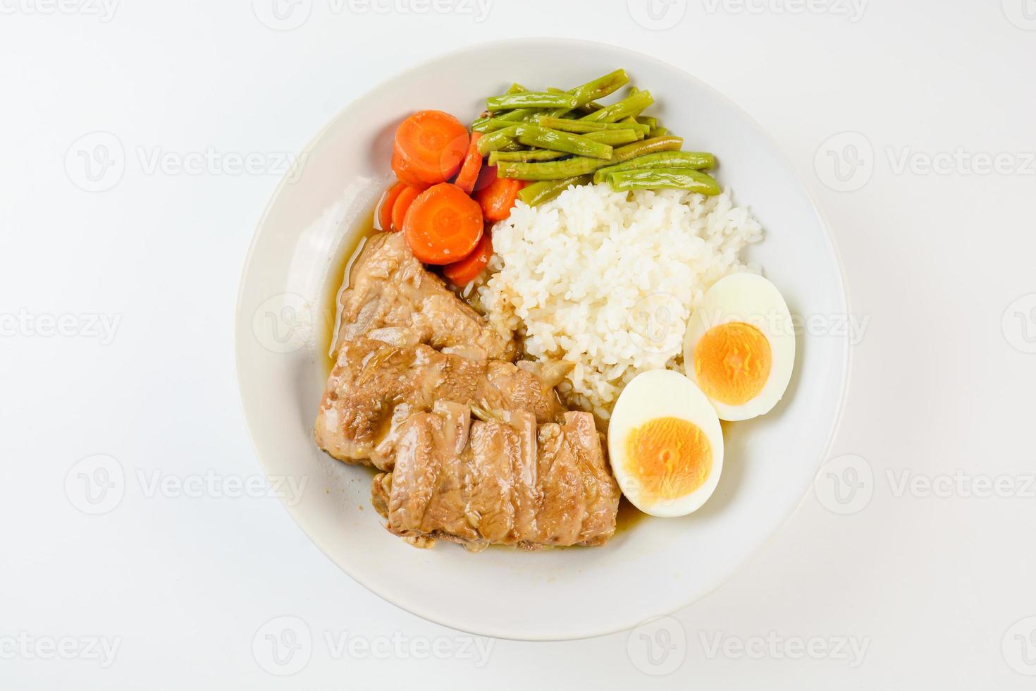 côtes de porc cuites au four avec riz, œuf à la coque et légumes photo