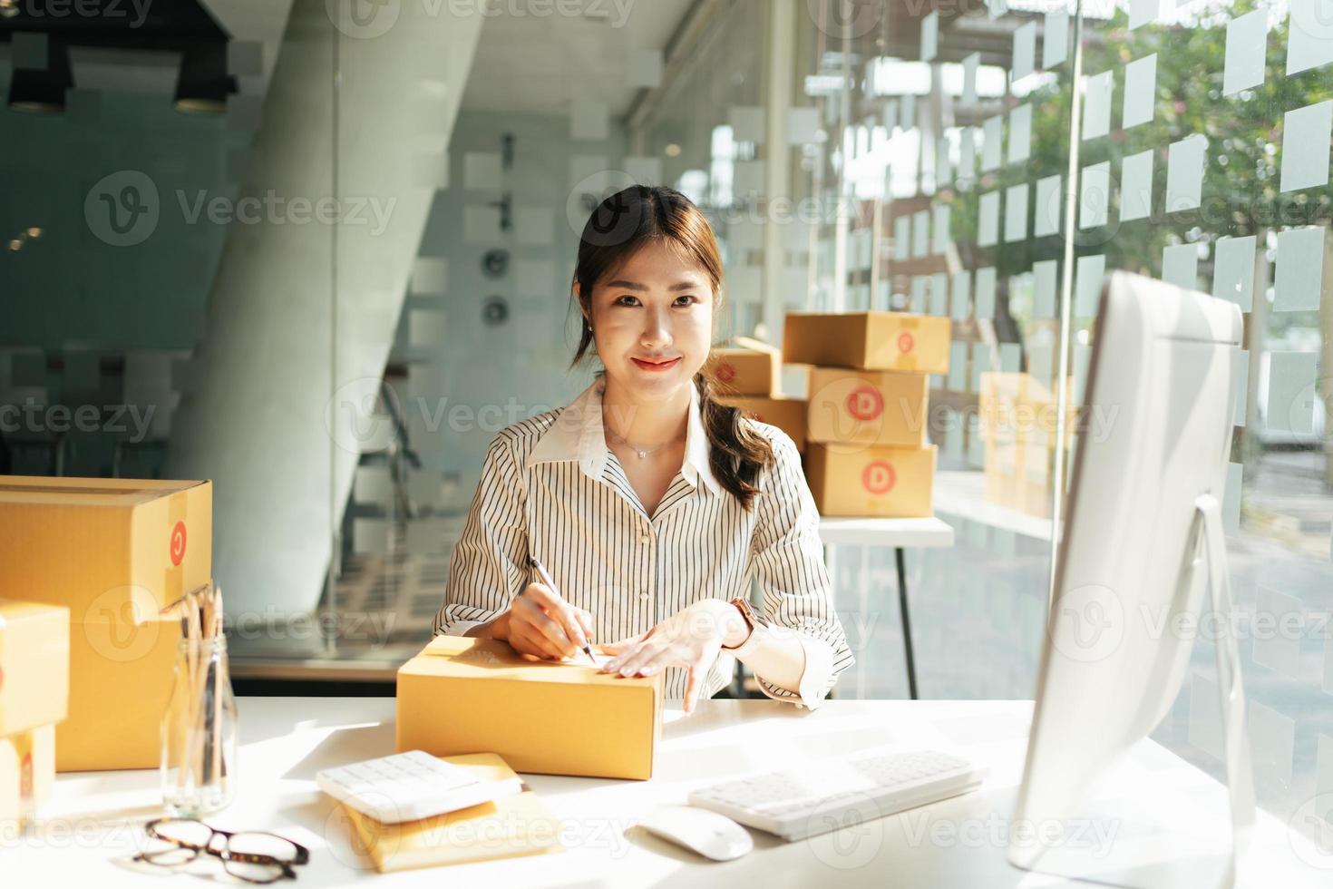 Démarrage de petites entreprises Propriétaires de PME Les femmes entrepreneurs écrivent l'adresse sur la boîte de réception et vérifient les commandes en ligne pour se préparer à emballer les boîtes, vendre aux clients, les idées commerciales des PME en ligne. photo