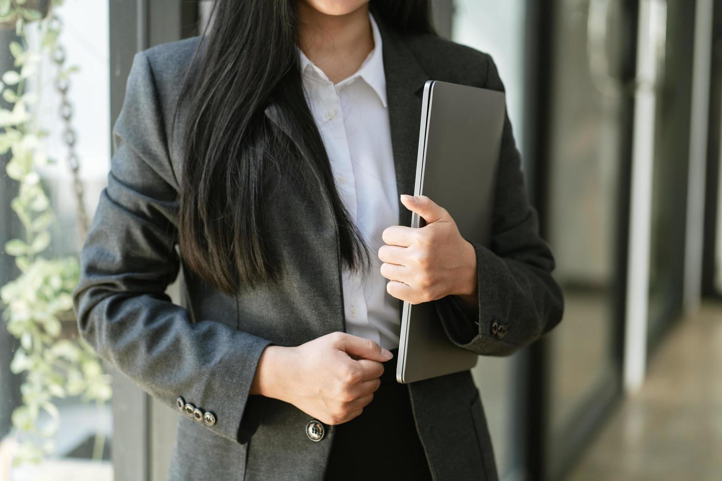 femme d'affaires tenant un ordinateur portable au bureau photo