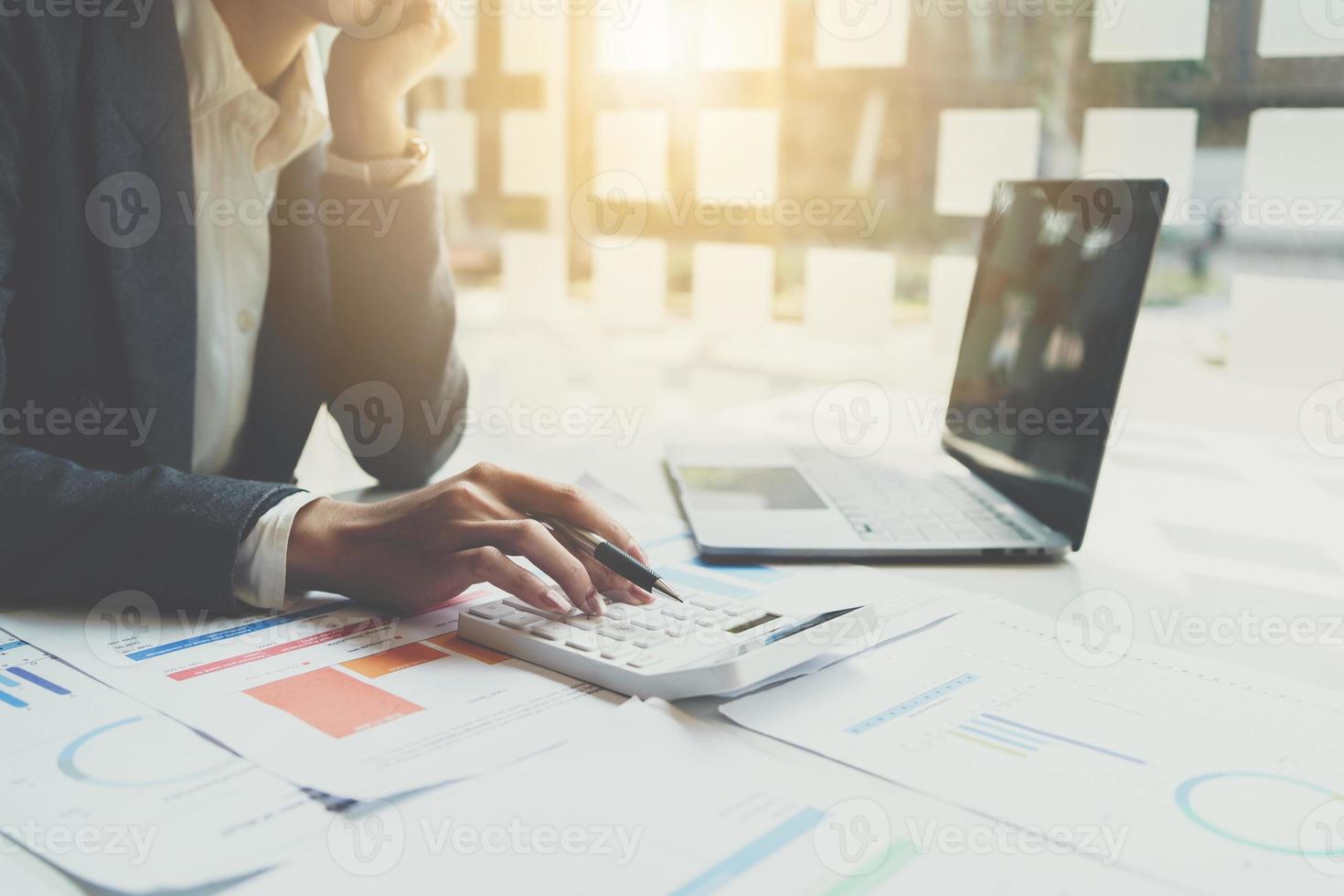 comptable travaillant sur le bureau à l'aide d'une calculatrice pour calculer le rapport financier au bureau. photo