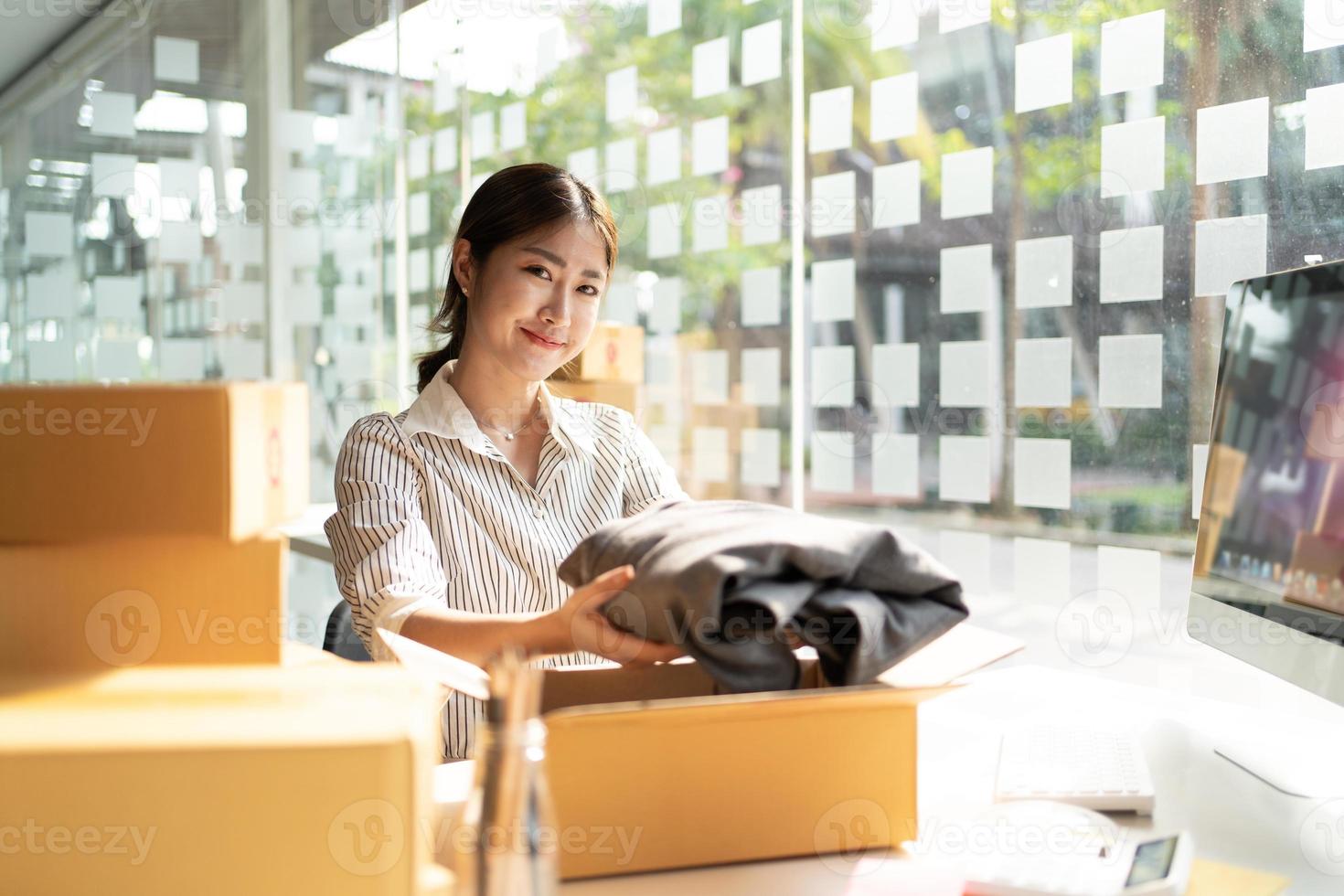 portrait jeune séduisante asie propriétaire femme démarrage entreprise travail heureux avec boîte à la maison préparer la livraison de colis dans la chaîne d'approvisionnement des PME, approvisionnement, concept de commerce en ligne omnicanal. photo