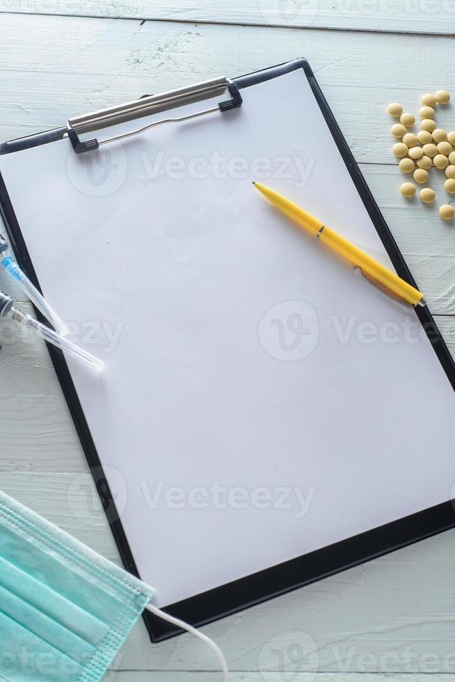 cahier pour notes, médicaments, seringues. tourné sur un fond en bois blanc d'en haut. photo