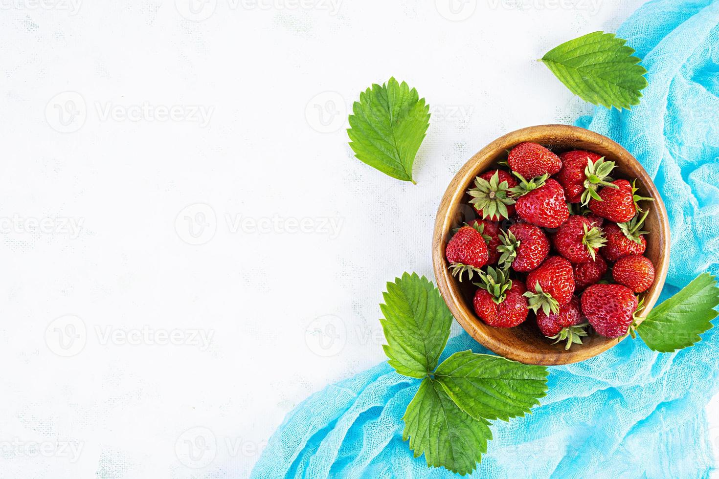 douce fraise mûre fraîche isolée sur un fond en bois blanc. photo