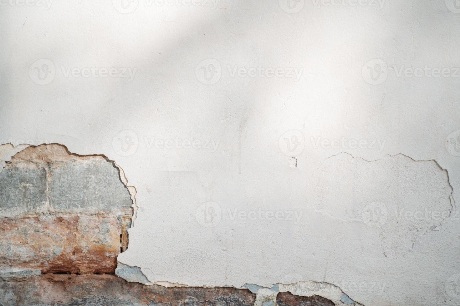 mur blanc avec peinture écaillée et détail de brique photo