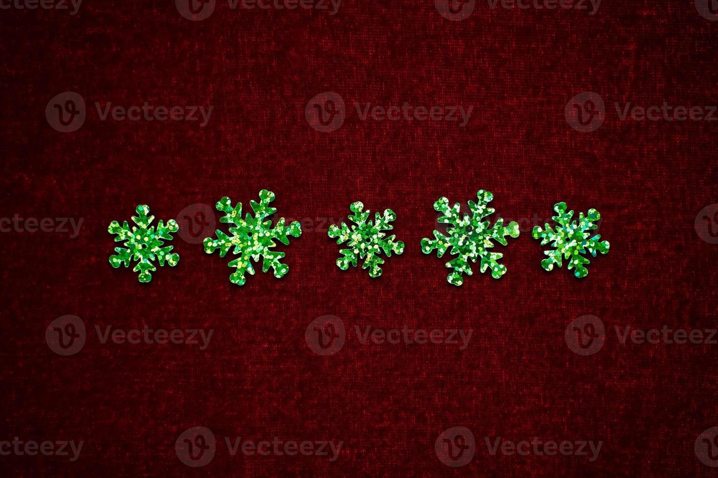 ligne de flocons de neige verts sur velours rouge photo