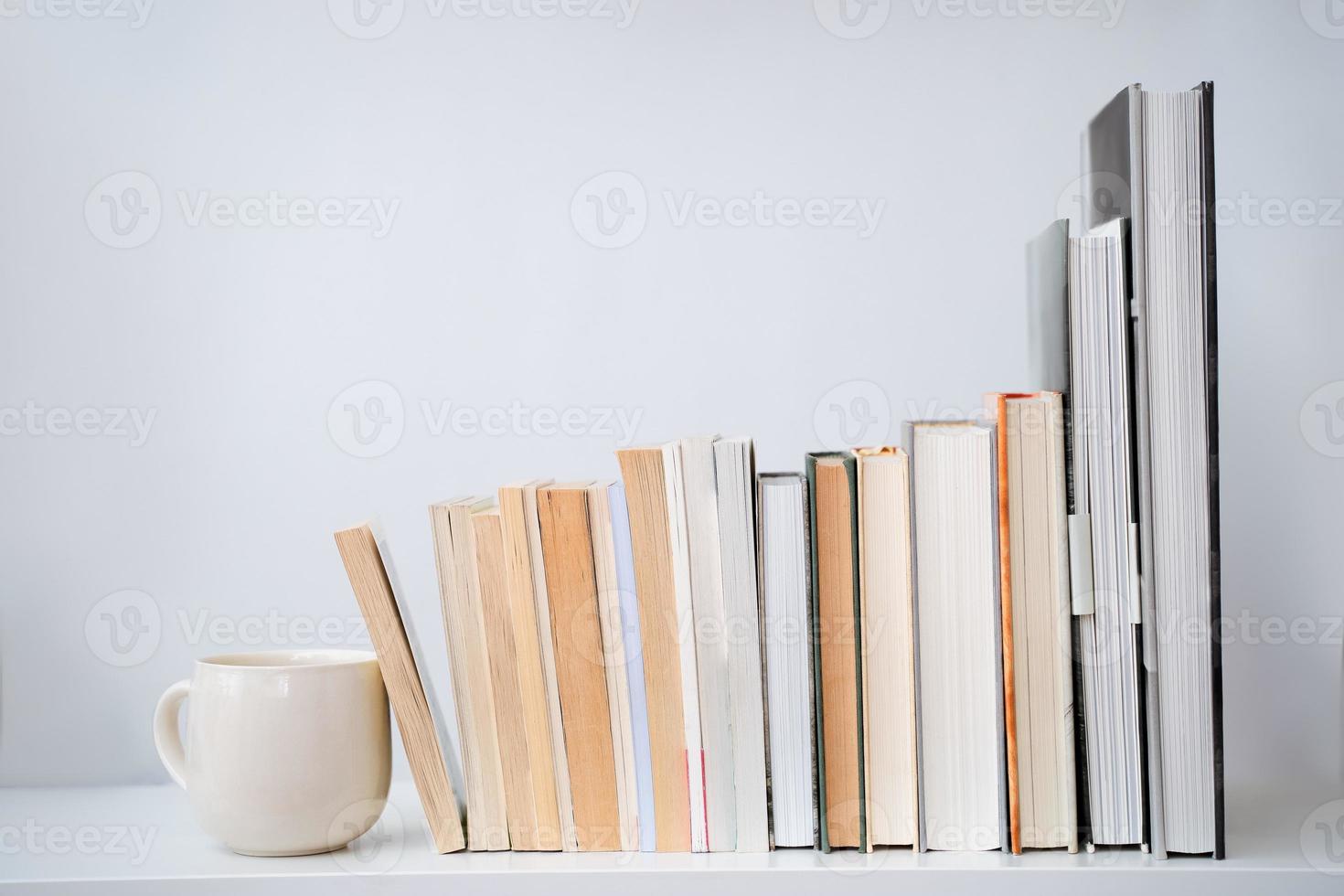 tasse à café tasse à thé à côté d'une pile de livres photo