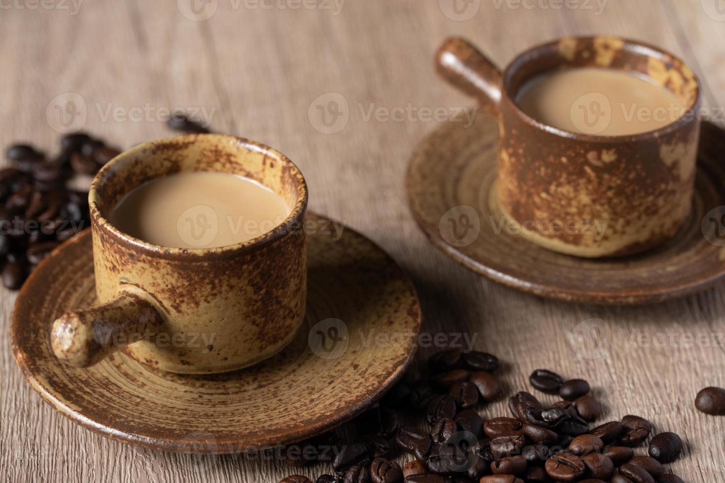 café chaud dans une tasse brune sur fond de bois photo